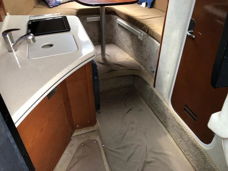 Slide: The Image of Interior of 2009 Sea Ray 270 Sundancer boat with kitchenette and seating area. - 21