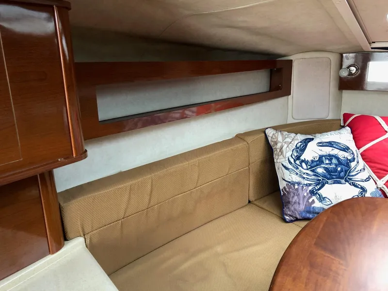 Slide: The Image of Interior cabin of 2009 Sea Ray 270 Sundancer with beige seating and decorative pillows. - 23