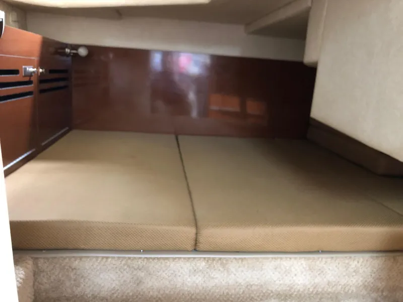 Slide: The Image of Interior cabin of 2009 Sea Ray 270 Sundancer with beige cushions and wooden paneling. - 28