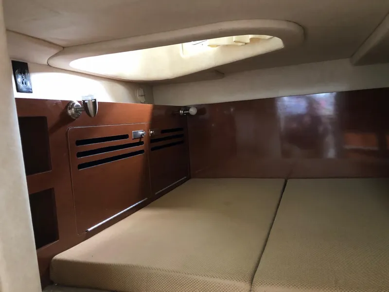 Slide: The Image of Interior cabin of 2009 Sea Ray 270 Sundancer with cushioned bed and wooden storage. - 29