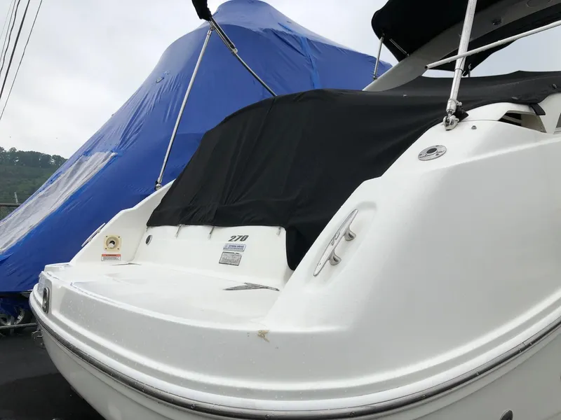 Slide: The Image of 2009 Sea Ray 270 Sundancer boat with black cover and blue tarp in background. - 3