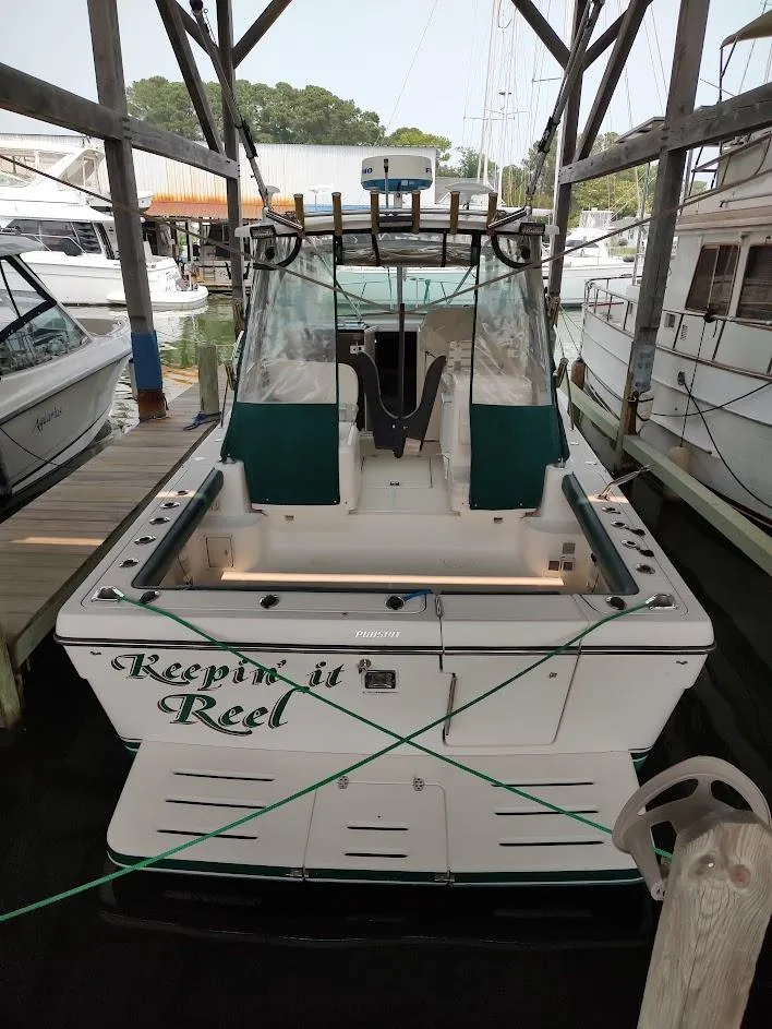 Slide: The Image of 2002 Pursuit 3000 Express boat docked, rear view with "Keepin it Reel" text. - 10