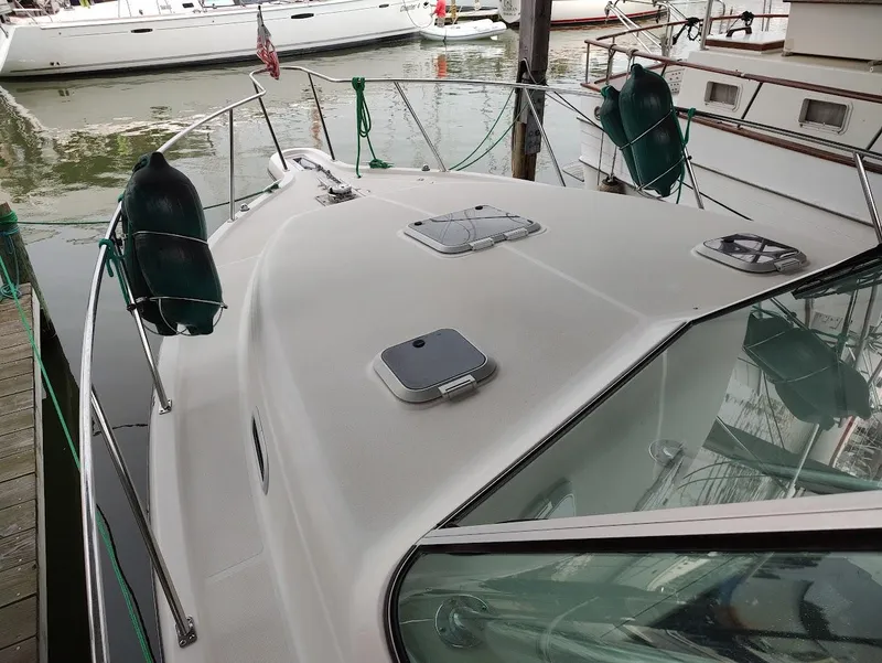 Slide: The Image of 2002 Pursuit 3000 Express boat docked, featuring deck and railing details. - 12