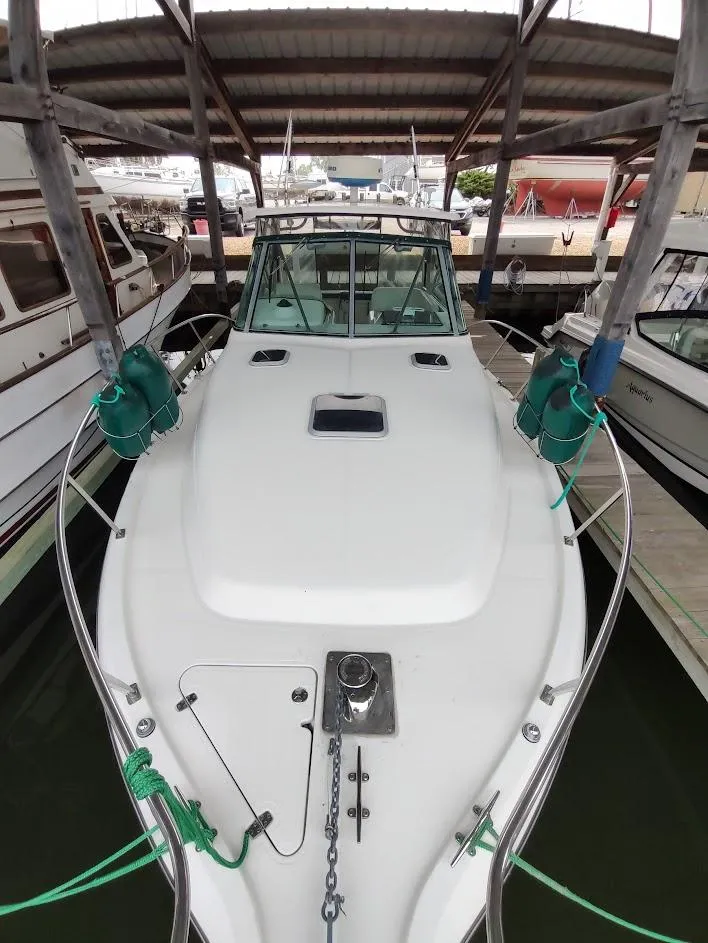 Slide: The Image of 2002 Pursuit 3000 Express boat docked under a covered marina. - 17