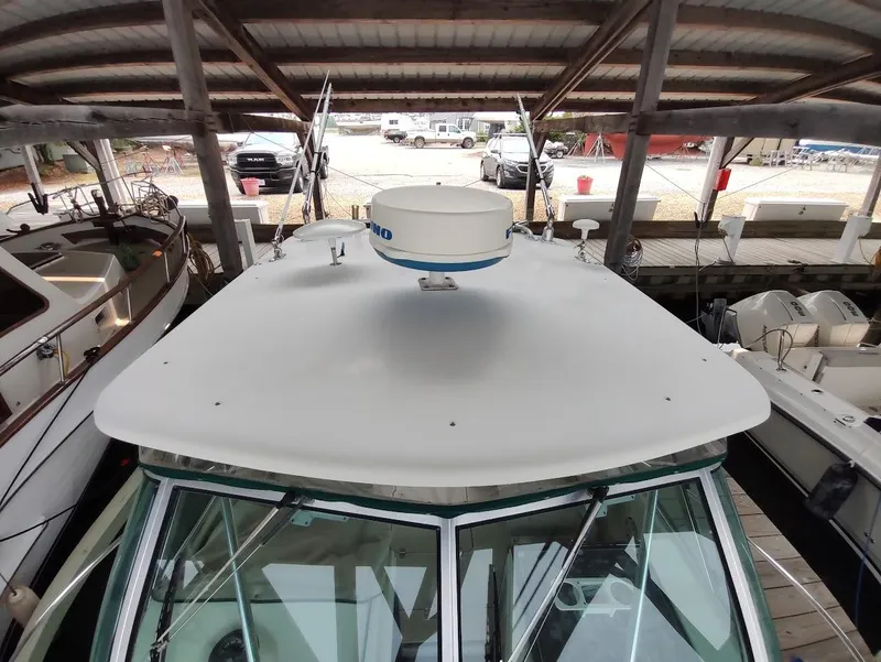 Slide: The Image of 2002 Pursuit 3000 Express boat docked under a covered marina. - 18