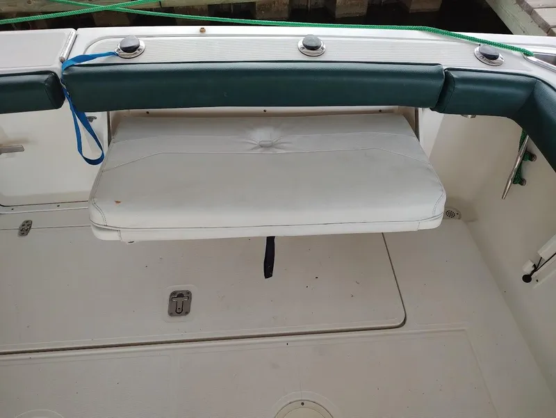 Slide: The Image of 2002 Pursuit 3000 Express boat with white cushioned seating and green trim. - 22