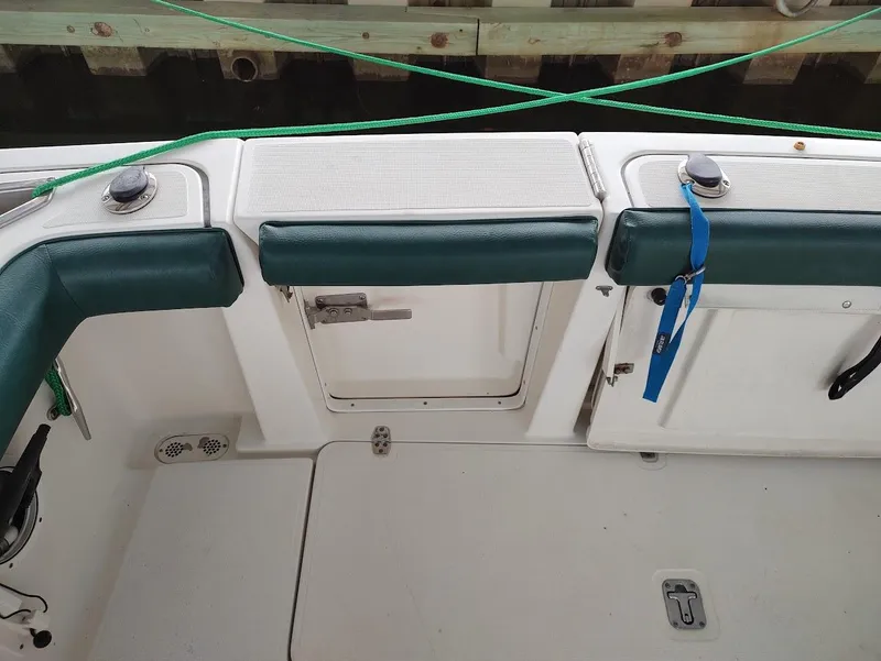 Slide: The Image of 2002 Pursuit 3000 Express boat interior with green seating and storage compartments. - 24