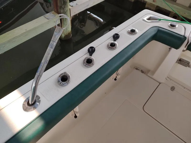 Slide: The Image of 2002 Pursuit 3000 Express boat deck with rod holders and wrench. - 26