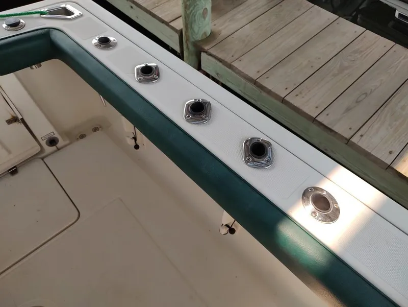 Slide: The Image of 2002 Pursuit 3000 Express boat deck with rod holders and green trim. - 27