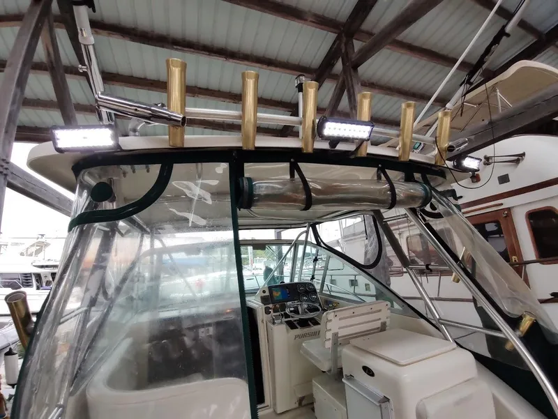 Slide: The Image of 2002 Pursuit 3000 Express boat cockpit with rod holders and navigation equipment. - 31