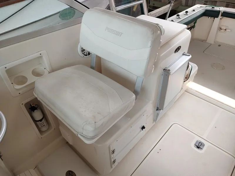 Slide: The Image of 2002 Pursuit 3000 Express boat interior with white seating and storage compartments. - 40