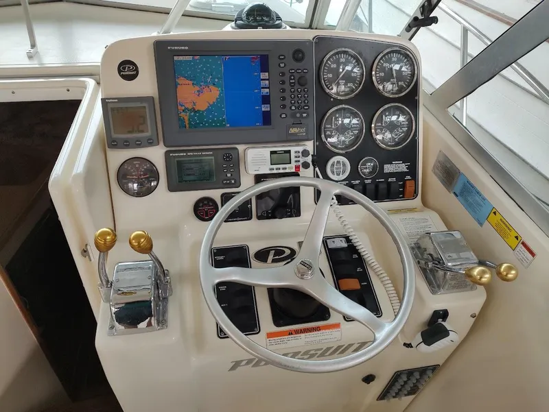 Slide: The Image of 2002 Pursuit 3000 Express boat dashboard with navigation and control instruments. - 43