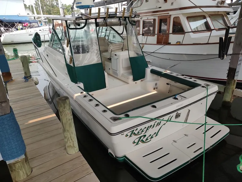Slide: The Image of 2002 Pursuit 3000 Express boat docked, featuring green accents and "Keepin' it Reel" text. - 8
