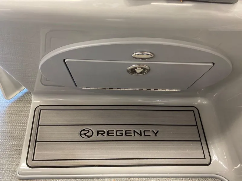 Slide: The Image of 2023 Regency 250 LE3 Sport boat interior with branded flooring and storage compartment. - 12
