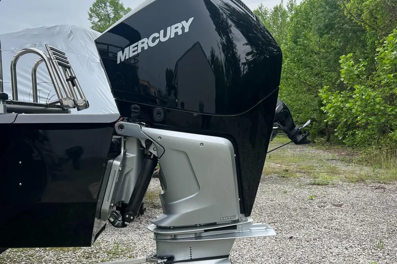 Slide: The Image of 2023 Regency 250 LE3 Sport boat with Mercury outboard motor, parked on gravel. - 3