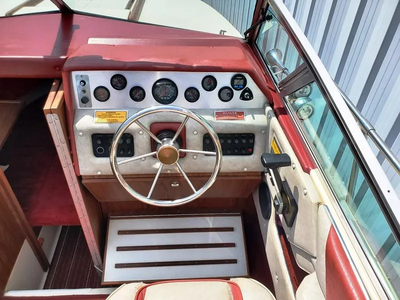 Slide: The Image of 1984 Sea Ray 225 Cuddy Cabin boat dashboard with steering wheel and instrument panel. - 12