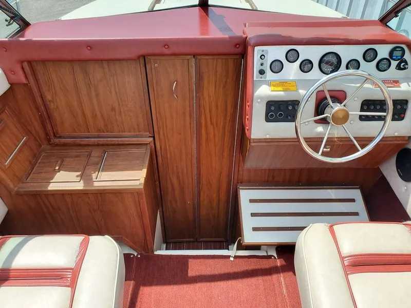 Slide: The Image of 1984 Sea Ray 225 Cuddy Cabin boat interior with wood paneling and red accents. - 4