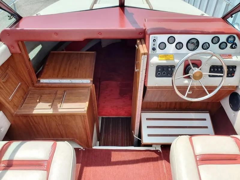 Slide: The Image of 1984 Sea Ray 225 Cuddy Cabin interior with red and wood accents, steering wheel, and control panel. - 5