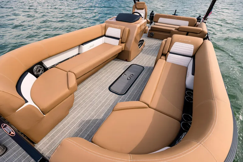 Slide: The Image of 2023 Harris Solstice 250 boat interior with tan seating on water. - 16