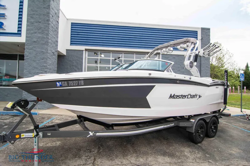 Slide: The Image of 2021 MasterCraft XStar boat on a trailer outside a dealership. - 0