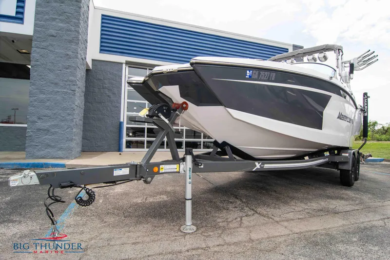 Slide: The Image of 2021 MasterCraft XStar boat on a trailer outside Big Thunder Marine dealership. - 3
