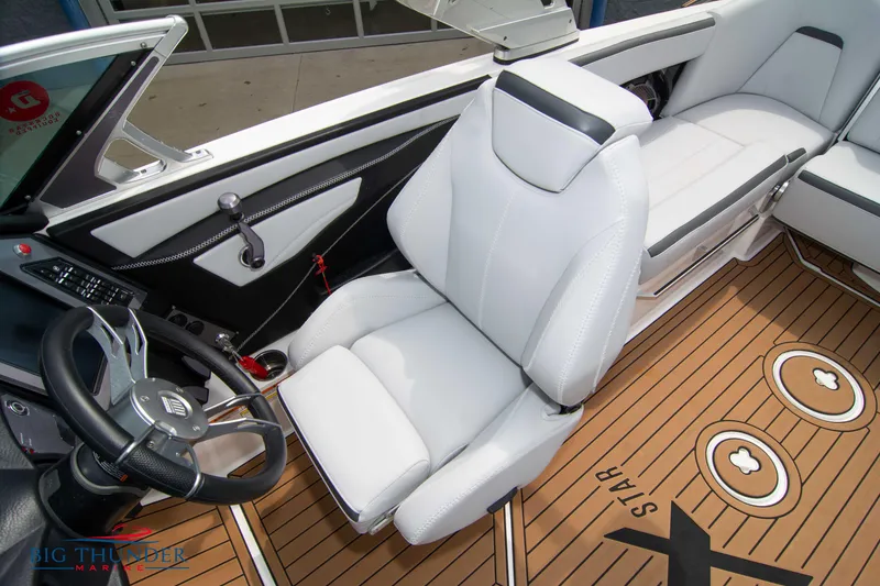 Slide: The Image of 2021 MasterCraft XStar boat interior with white captain's chair and teak flooring. - 31