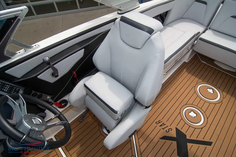 Slide: The Image of 2021 MasterCraft XStar boat interior with white captain's chair and teak flooring. - 32