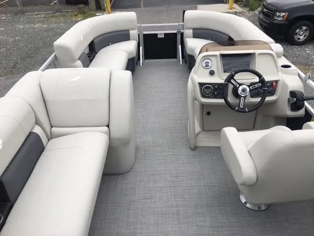 Slide: The Image of 2023 Starcraft LX 18 R pontoon boat interior with beige seating and modern helm. - 2