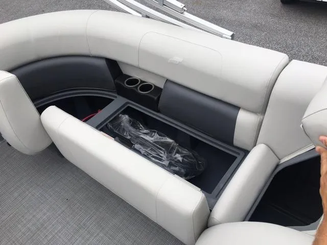 Slide: The Image of 2023 Starcraft LX 18 R boat interior with storage compartment and cup holders. - 3