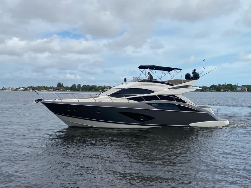Slide: The Image of 2017 Marquis 500 Sport Yacht cruising on a calm waterway. - 0