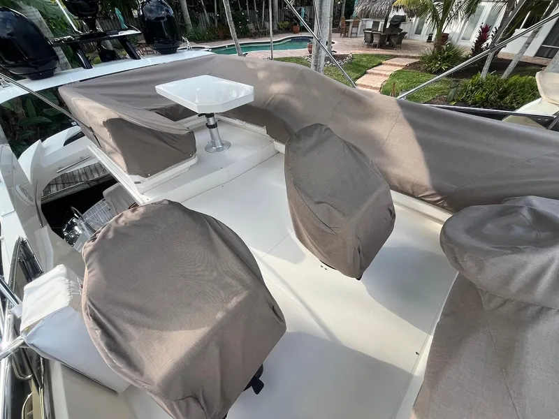 Slide: The Image of 2017 Marquis 500 Sport Yacht deck with covered seating and table. - 19