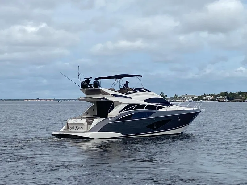 Slide: The Image of 2017 Marquis 500 Sport Yacht cruising on a calm waterway. - 2