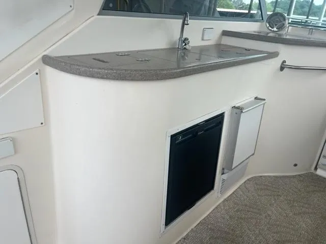 Slide: The Image of 2007 Rinker 420 Express Cruiser kitchenette with sink, countertop, and mini fridge. - 3