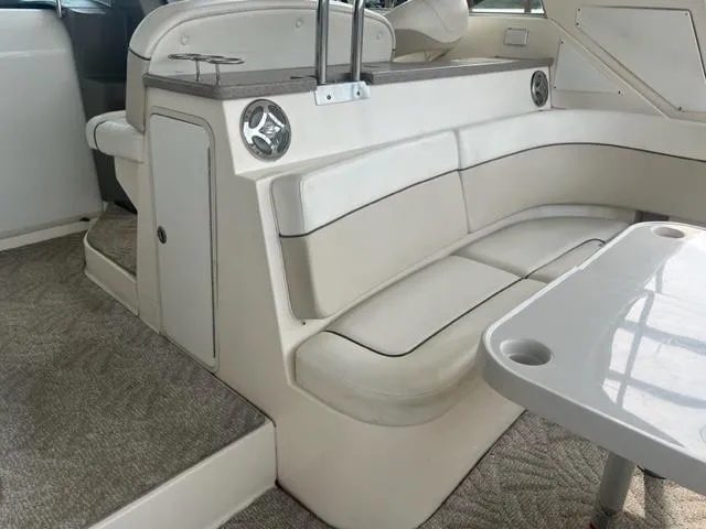 Slide: The Image of 2007 Rinker 420 Express Cruiser interior seating area with white upholstery and table. - 9