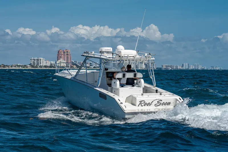 Slide: The Image of 2007 Marlin Yachts 42 cruising on open water with city skyline in background. - 2