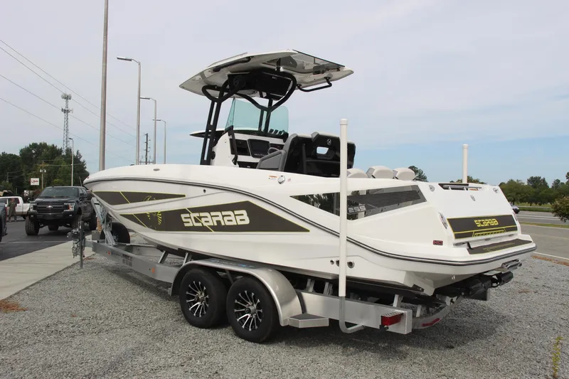 Slide: The Image of 2023 Scarab 255 Open ID boat on trailer, parked outdoors. - 3