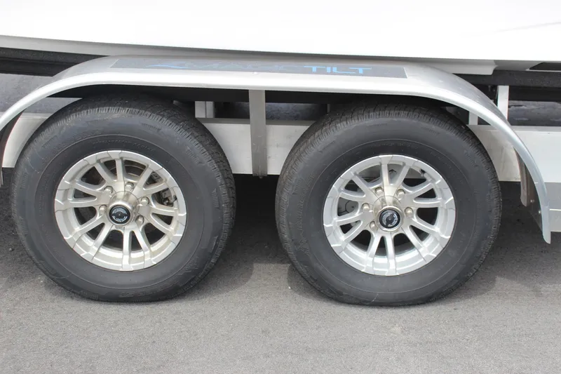 Slide: The Image of 2023 Scarab 255 Open ID trailer wheels on pavement. - 17