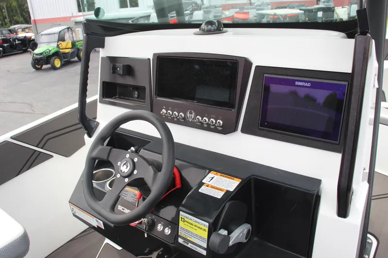 Slide: The Image of 2023 Scarab 255 Open ID boat dashboard with steering wheel and navigation controls. - 8