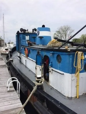 Slide: The Image of 1903 Johnson Brother Tug 64 docked at a marina. - 13