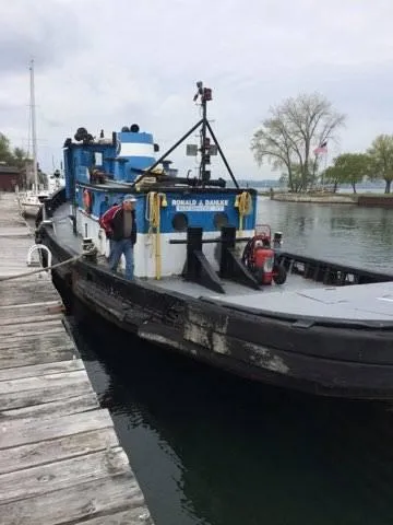 Slide: The Image of Historic 1903 Johnson Brother Tug 64 docked at a pier. - 14