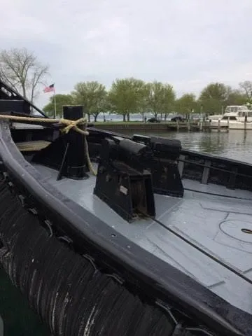 Slide: The Image of Historic 1903 Johnson Brother Tug 64 docked by a serene waterfront. - 15