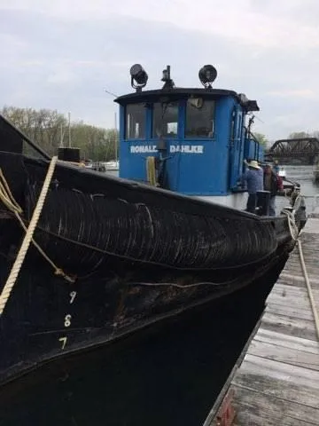 Slide: The Image of 1903 Johnson Brother Tug 64 docked at a pier. - 17