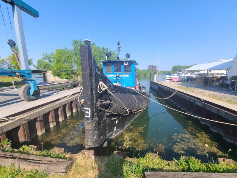 Slide: The Image of Historic 1903 Johnson Brother Tug 64 docked in a narrow canal. - 23