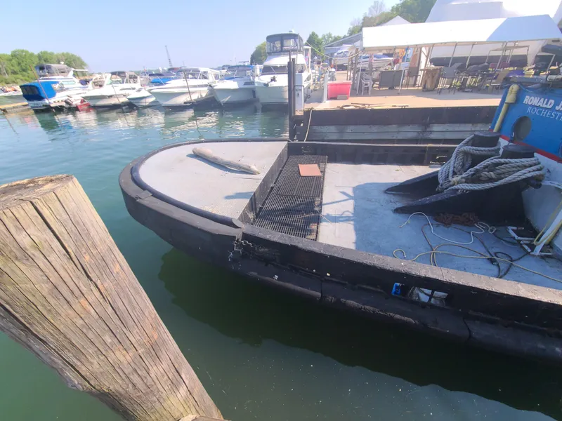 Slide: The Image of 1903 Johnson Brother Tug 64 docked at a marina with other boats. - 24