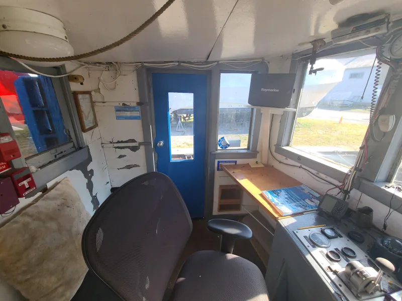 Slide: The Image of Interior of 1903 Johnson Brother Tug 64, featuring control room with chair and navigation equipment. - 28