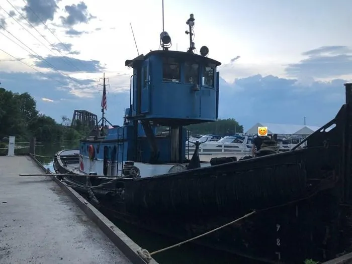 Slide: The Image of 1903 Johnson Brother Tug 64 docked at a marina during sunset. - 8