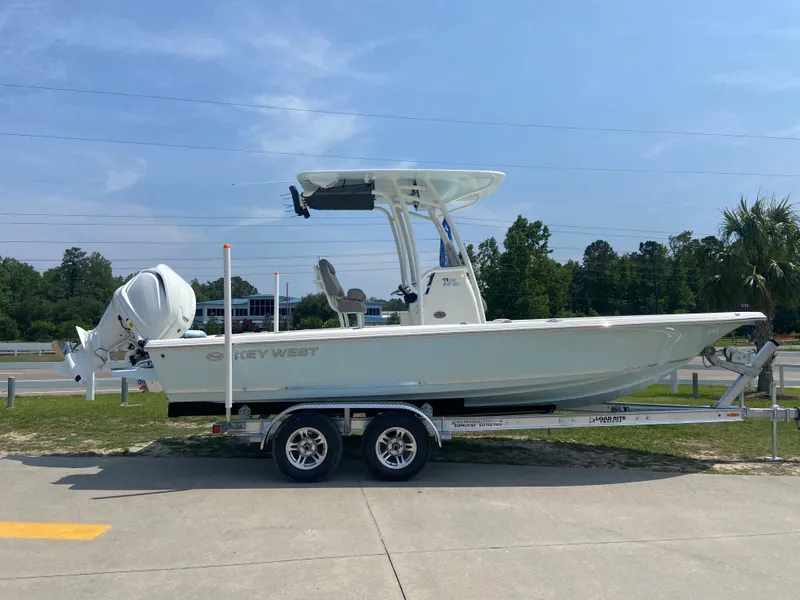 Slide: The Image of 2024 Key West 230 Bay Reef boat on a trailer in a parking lot. - 1