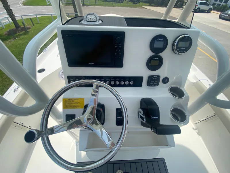 Slide: The Image of 2024 Key West 230 Bay Reef boat dashboard with steering wheel, gauges, and navigation screen. - 17