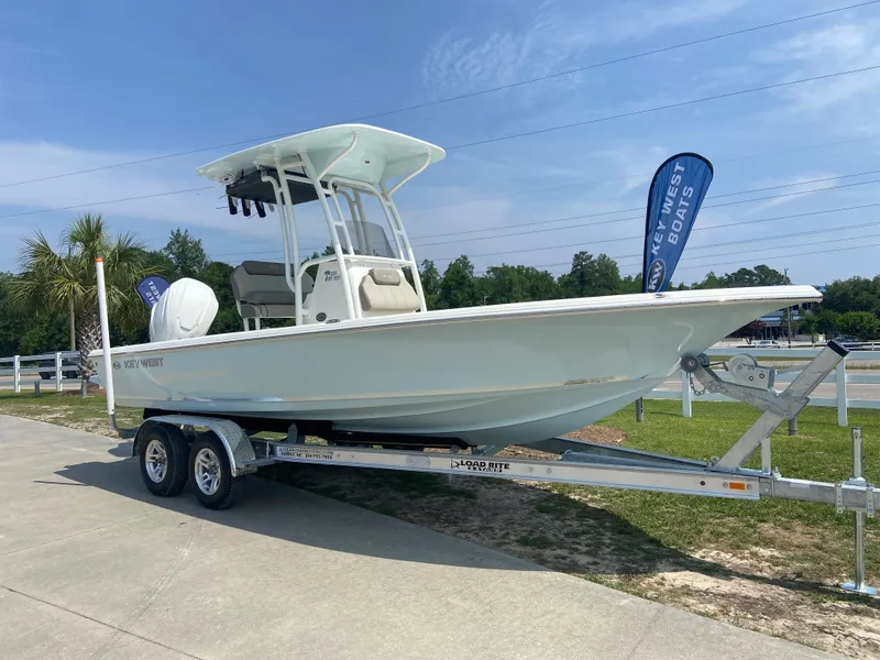 Slide: The Image of 2024 Key West 230 Bay Reef boat on a trailer, displayed outdoors. - 2