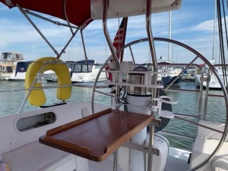 Slide: The Image of Cockpit of 1999 Catalina 36 Mark II sailboat with wheel, table, and marina view. - 17